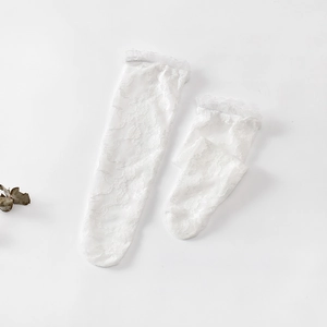 Dettaglio di calze al ginocchio in pizzo floreale bianco con volant in mesh fine