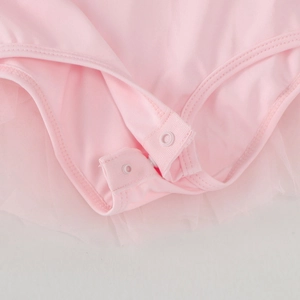 Detail of pink ballet bodysuit featuring bottom snap buttons and soft tutu mesh fabric