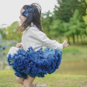 Detailed close-up of girls navy blue layered tulle tutu skirt and satin bow hair clip
