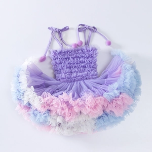 Detail of colorful tiered tulle tutu dress with pom-pom shoulder straps and soft pastel layers