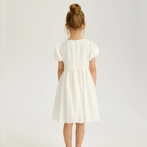 Vue détaillée du dos d'une robe blanche pour fille avec manches bouffantes et zip caché