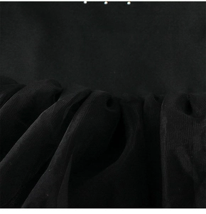 Détail d'une robe de ballet pour filles montrant le tissu noir lisse et le tulle plissé