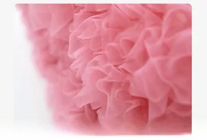 Detail of high-density pink tulle layers showing fluffy pleats and refined texture