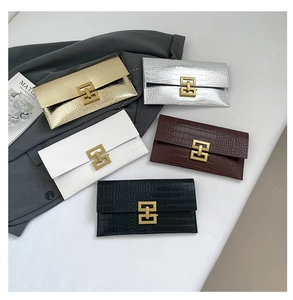 Close-up of crocodile pattern texture and golden interlocking metal clasp on envelope clutch