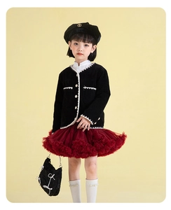 Detail of girls winter outfit with tweed cardigan and red layered mesh tutu skirt
