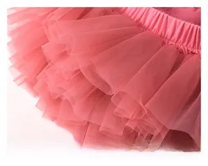 Detailed close-up of layered peach pink tutu skirt with high-density soft mesh fabric