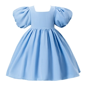 Détail d'une robe bleue pour fille avec col carré, manches bouffantes et jupe trapèze