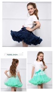 Detail view of multi-layered tulle tutu skirts in navy and mint with satin bow accents