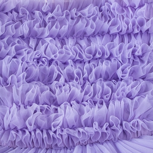 Close-up of elegant light purple pleated mesh fabric with layered wavy ruffles for tutu dress