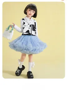 Girl's light blue tutu skirt paired with a cow print vest and stylish white shirt