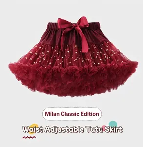 Détail de jupe tutu rouge avec étoiles dorées, taille réglable et nœud en satin