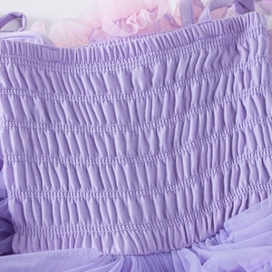 Detail of purple smocked bodice with ruffled tulle trim on toddler princess party dress