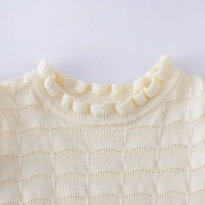 Détail du haut en tricot crème pour filles avec col volanté et texture en point de coquille