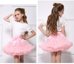 Close-up of white T-shirt with lace sleeves and pink layered tutu skirt with satin bow