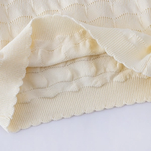 Détail du tricot crème avec motif festonné et bord-côte sur le haut de jupe tutu