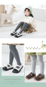 Detailed macro view of knit cotton baby leggings featuring vertical stripe and cable patterns