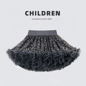 Detailed view of dark grey tutu skirt featuring shimmering gold stars and elastic waist
