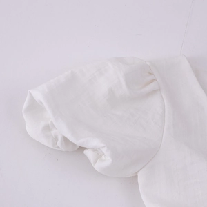 Détail des manches bouffantes en coton blanc avec poignets plissés pour filles