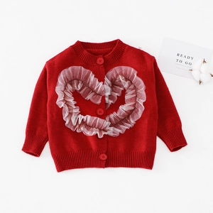 Detail der roten Strickjacke mit weißem Herz aus Netzrüschen und Knöpfen für Kinder