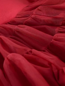 Detailed view of layered red mesh fabric with delicate ruffles for a tutu skirt