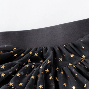 Detail of dark grey tutu skirt with golden star patterns on layered mesh fabric