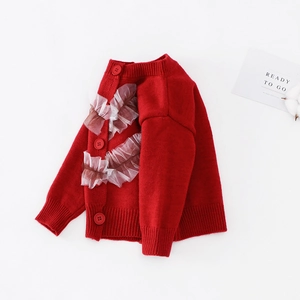 Detail der roten Mädchen Strickjacke mit elegantem weißen Netzrüschenbesatz und Knöpfen