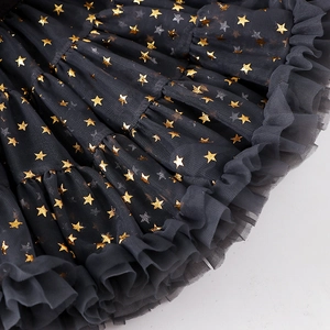 Detail of dark grey tulle skirt with gold star prints and pleated ruffle hem for girls