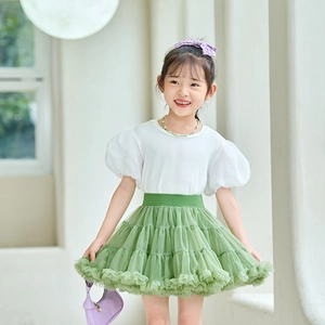Detail of girls puff sleeve white T-shirt and layered green tulle tutu skirt set
