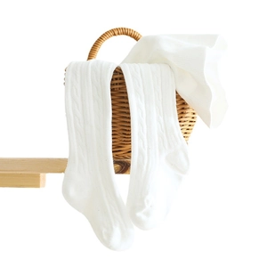 White cable-knit cotton leggings for girls shown on a woven basket for kids