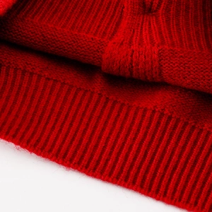 Nahaufnahme von rotem Grobstrickpullover mit geripptem Saum und weicher Struktur