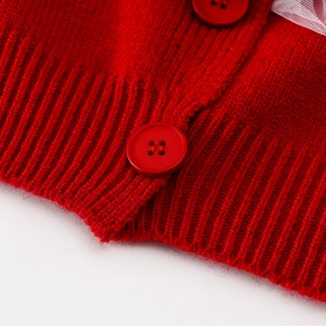 Makro-Detail von rotem Strick-Cardigan-Saum mit passenden Knöpfen und Spitzenrock