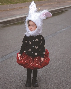 Détail du cardigan noir à étoiles dorées et jupe tutu en tulle rouge pour fille