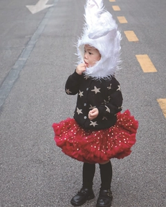 Détail de la tenue de fête pour fille avec cardigan noir et jupe tutu rouge à paillettes