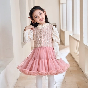 Detailed view of girls' white ruffle collar top with pink tweed dress and pearl buttons