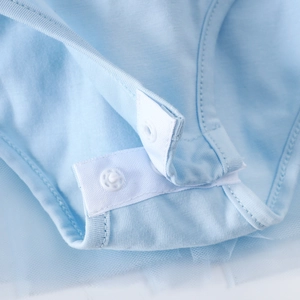 Vue détaillée de la robe de ballet pour bébé montrant le coton bleu et les boutons