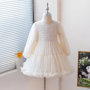 Detailed view of cream lace smocking and layered tulle mesh on a girl's princess dress