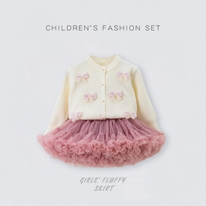 Detail of girls' cream knit cardigan with pink bows and layered pink tutu tulle skirt