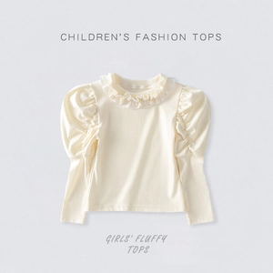 Close-up of girls' ruffle collar and puff sleeves on cream fashion top for autumn