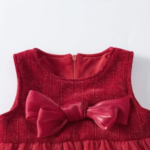 Close-up of girls red dress with satin bow and shimmering metallic gold thread texture