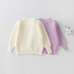 Detailed flat lay of soft knit sweaters for girls in beige and light purple colors
