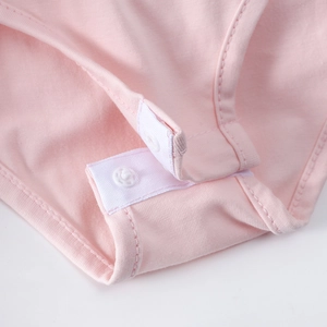 Détail de l'entrejambe d'un justaucorps de ballet rose avec boutons-pression en coton doux