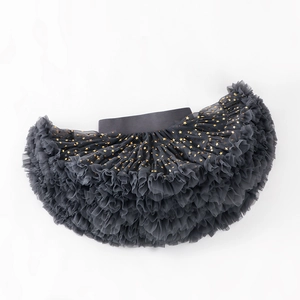 Detail of dark grey girls tutu skirt featuring golden foil star patterns on layered mesh fabric