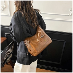 Détail d'un sac cabas vintage marron avec poche à boucle fonctionnelle et marquage latéral