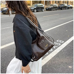 Détail d'un sac hobo en cuir marron vintage avec poche zippée et boucle en métal