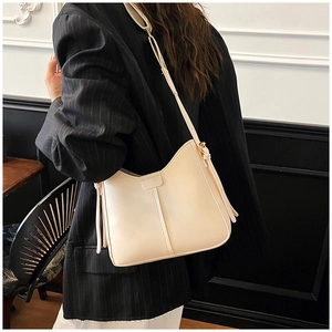 Detail view of cream white shoulder bag showing smooth synthetic leather and strap