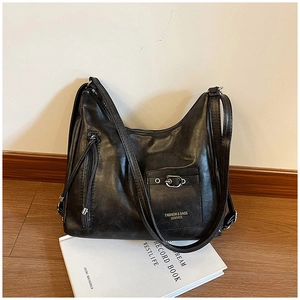 Détail du sac à bandoulière en cuir PU souple noir avec boucles dorées et fermeture éclair