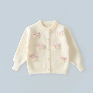 Detail of cream knit cardigan with pink mesh bows and pearl buttons for girls