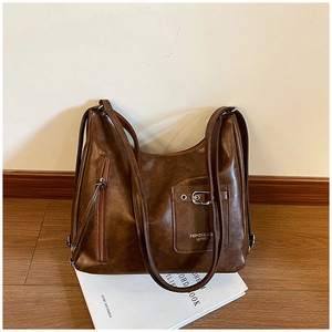 Détail du sac en cuir marron rétro avec boucle en métal et poche latérale à fermeture