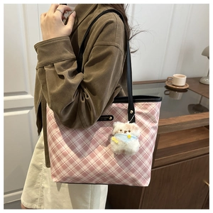 Detail of pink and white checkered tote bag with leather straps and plush bear charm