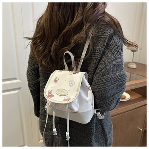 Lifestyle view of a mini white backpack with cute rabbit and bear prints on a model